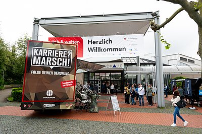 Messeingang mit Herzlich-Willkommen-Plakat sowie Bundeswehr-Bus